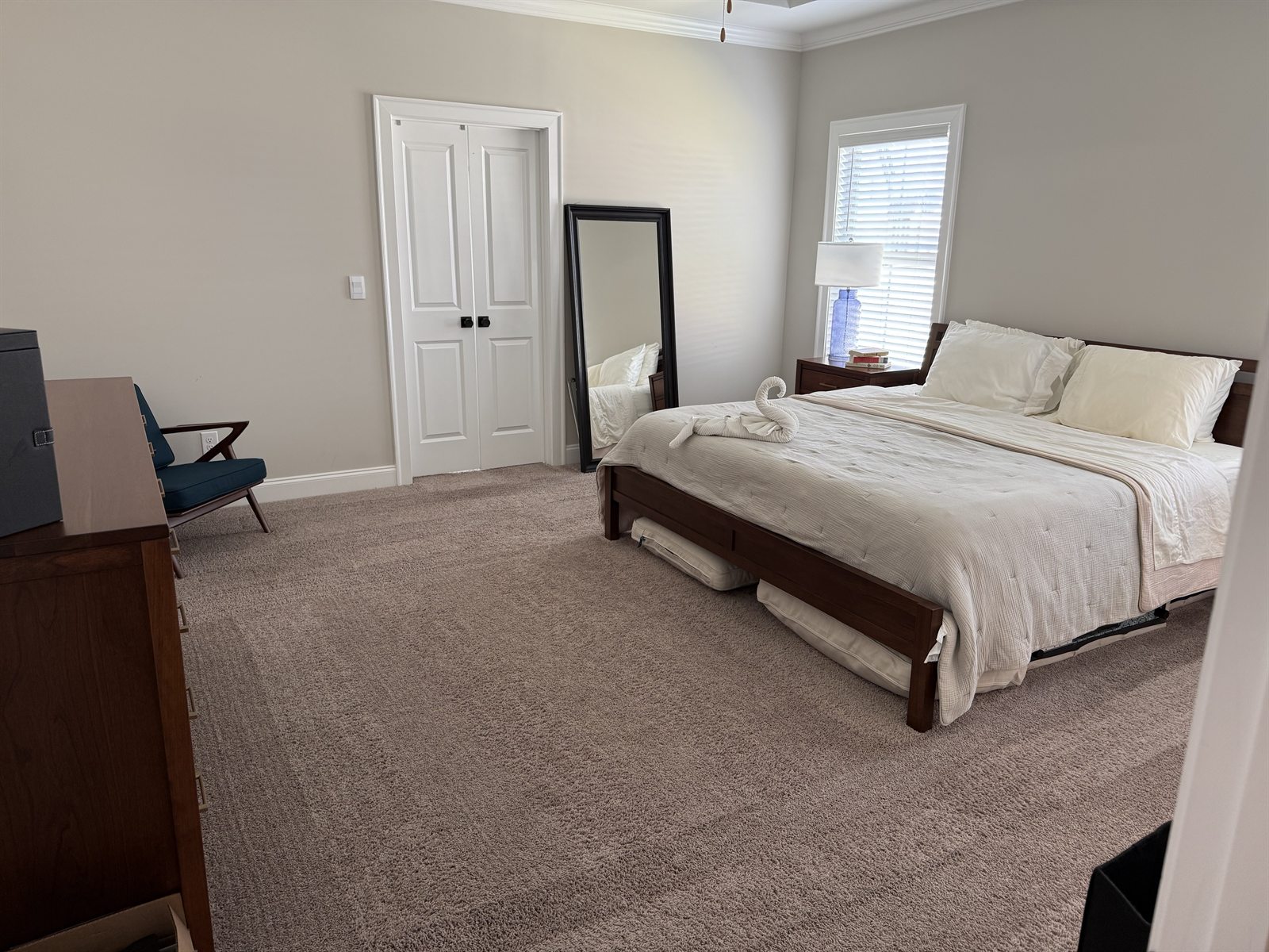 Bedroom after professional cleaning service &mdash; made bed and polished surfaces