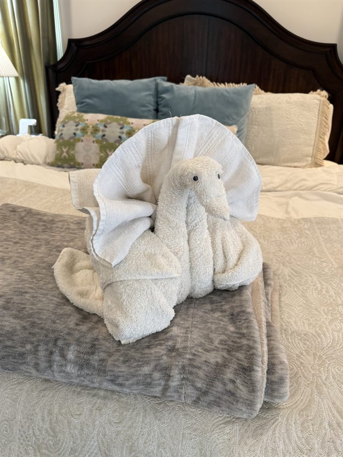 Finishing touch styling &mdash; decorative towel fold on freshly made bed
